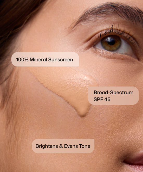 Close up of woman applying Revision Skincare Intellishade TruPhysical 100% Mineral Broad-Spectrum SPF45 Sunscreen to brighten and even tone. 